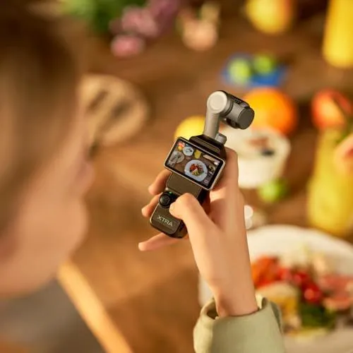 A person holding a compact gimbal camera over a dinner table