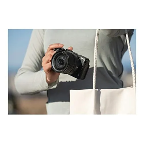 A person holding a Nikon mirrorless camera