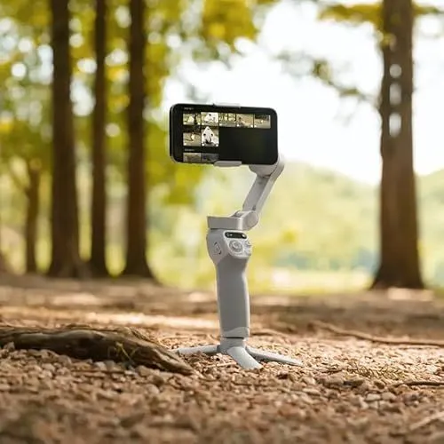 A smartphone gimbal standing on a forest floor