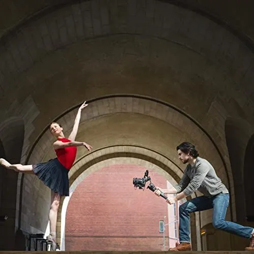 Filmmaker Filming a Ballerina Under a Stone Archway