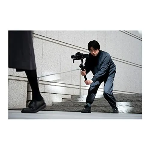 Filmmaker operating a camera gimbal on outdoor stairs