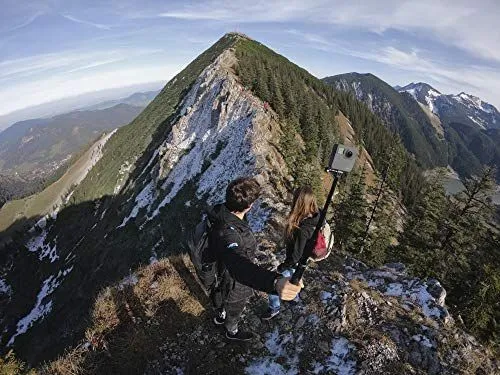 Hikers capturing a scenic mountain ridge with a 360 degree camera
